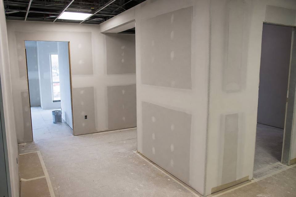 Commercial drywall finishing with corner bead and floor protection for Daytona Beach drywall projects